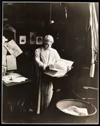 David Belasco steht und hält ein Wörterbuch, nach 1909